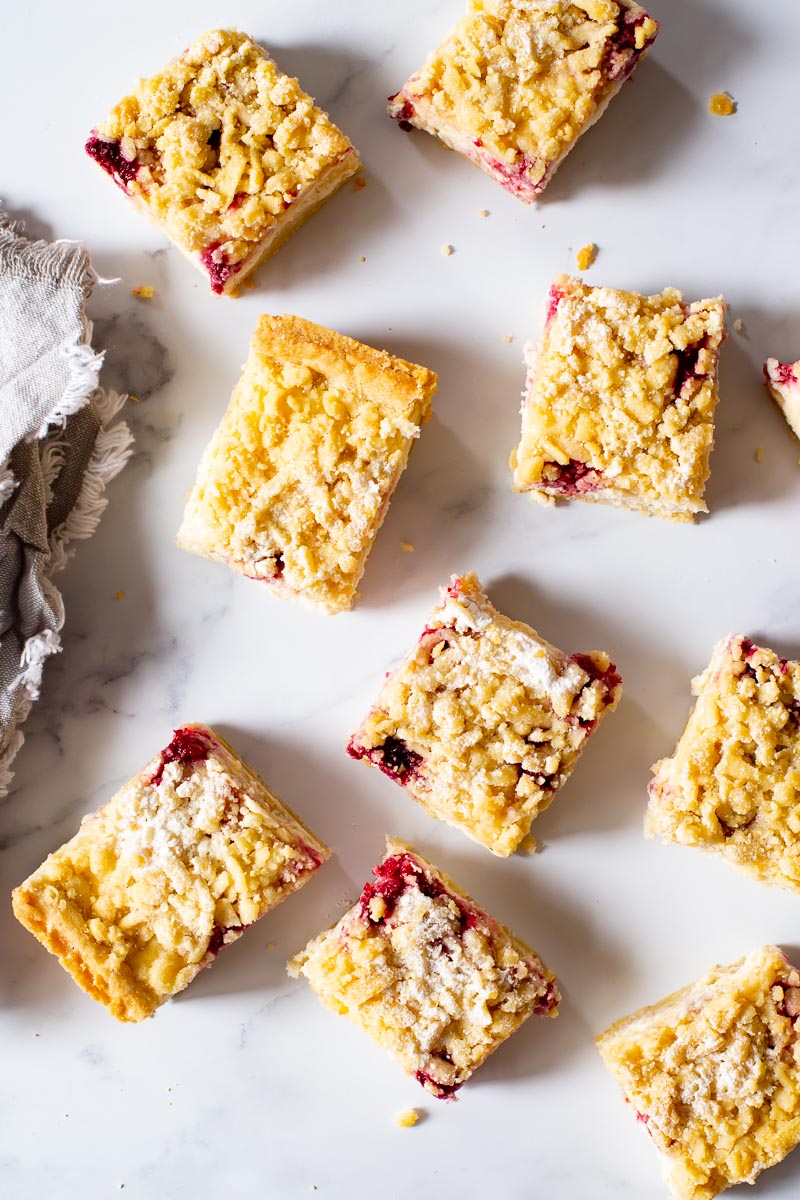 raspberry cheesecake bars on white background. Overhead view.