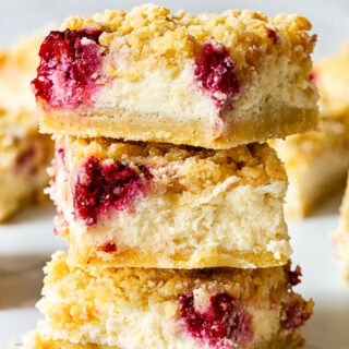 3 raspberry cheesecake bars stacked on top on each other