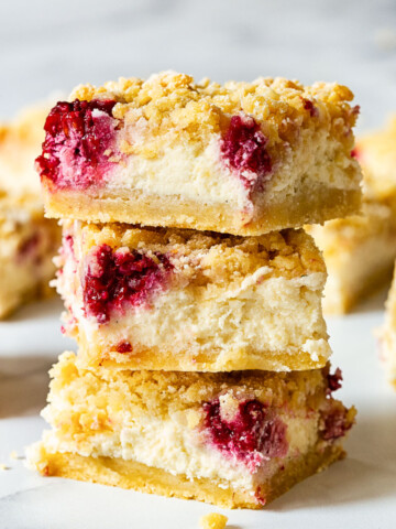 3 raspberry cheesecake bars stacked on top on each other
