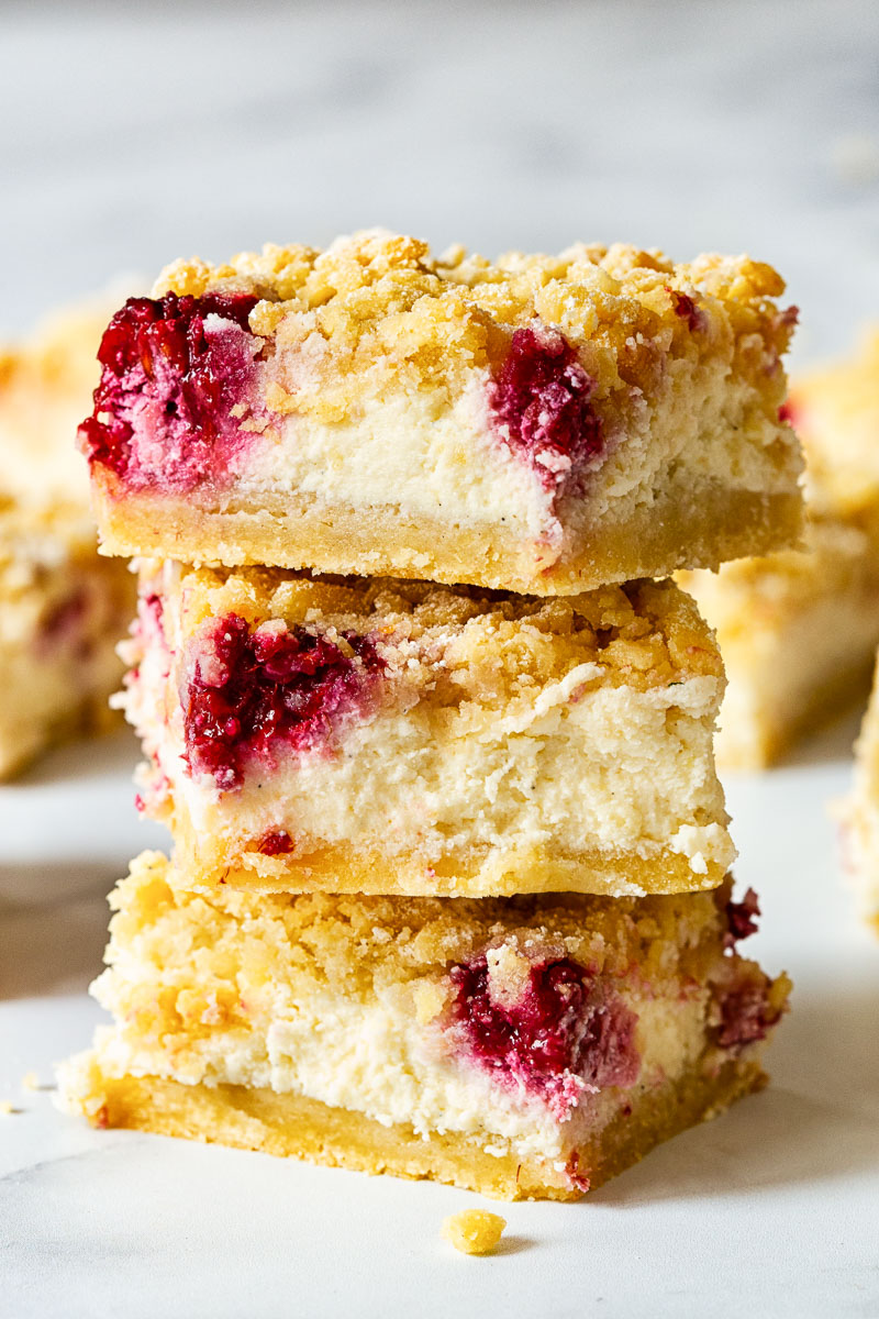 3 raspberry cheesecake bars stacked on top on each other