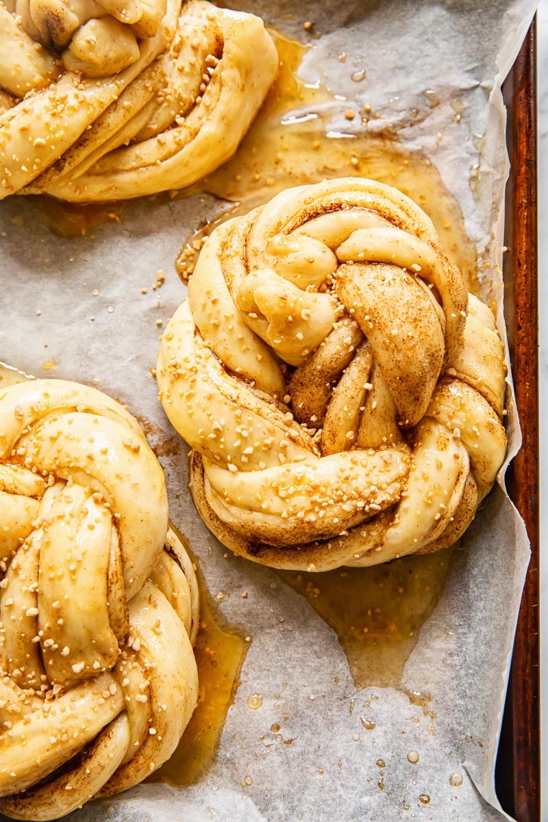 unbaked cinnamon buns on baking sheet