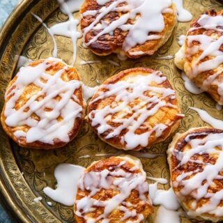 overhead view of apple fritters drizzled with sugar glaze on platter