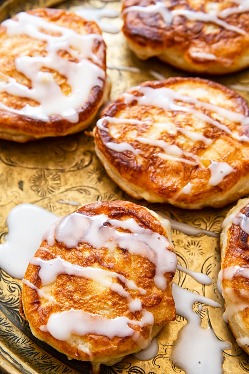 apple fritters drizzled with sugar glaze close up