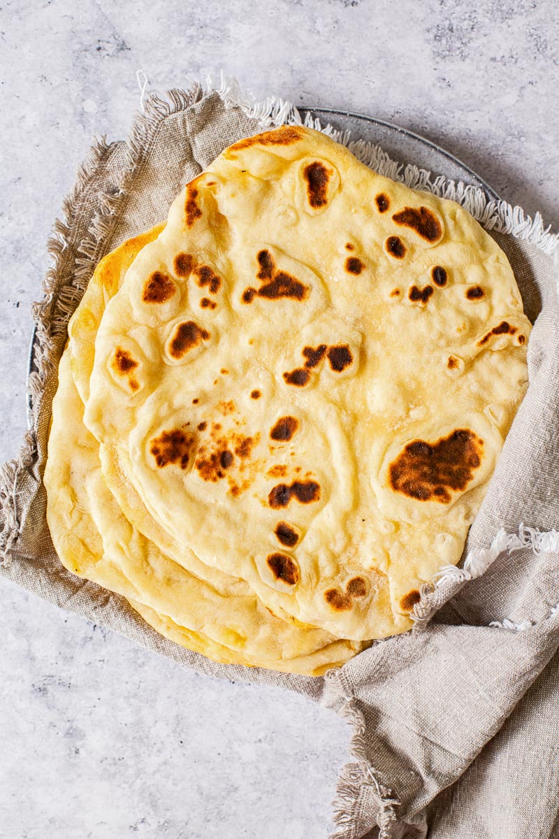 pita breads stacked wrapped into grey cloth napkin