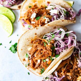 soft corn tacos filled with pulled pork and slaw