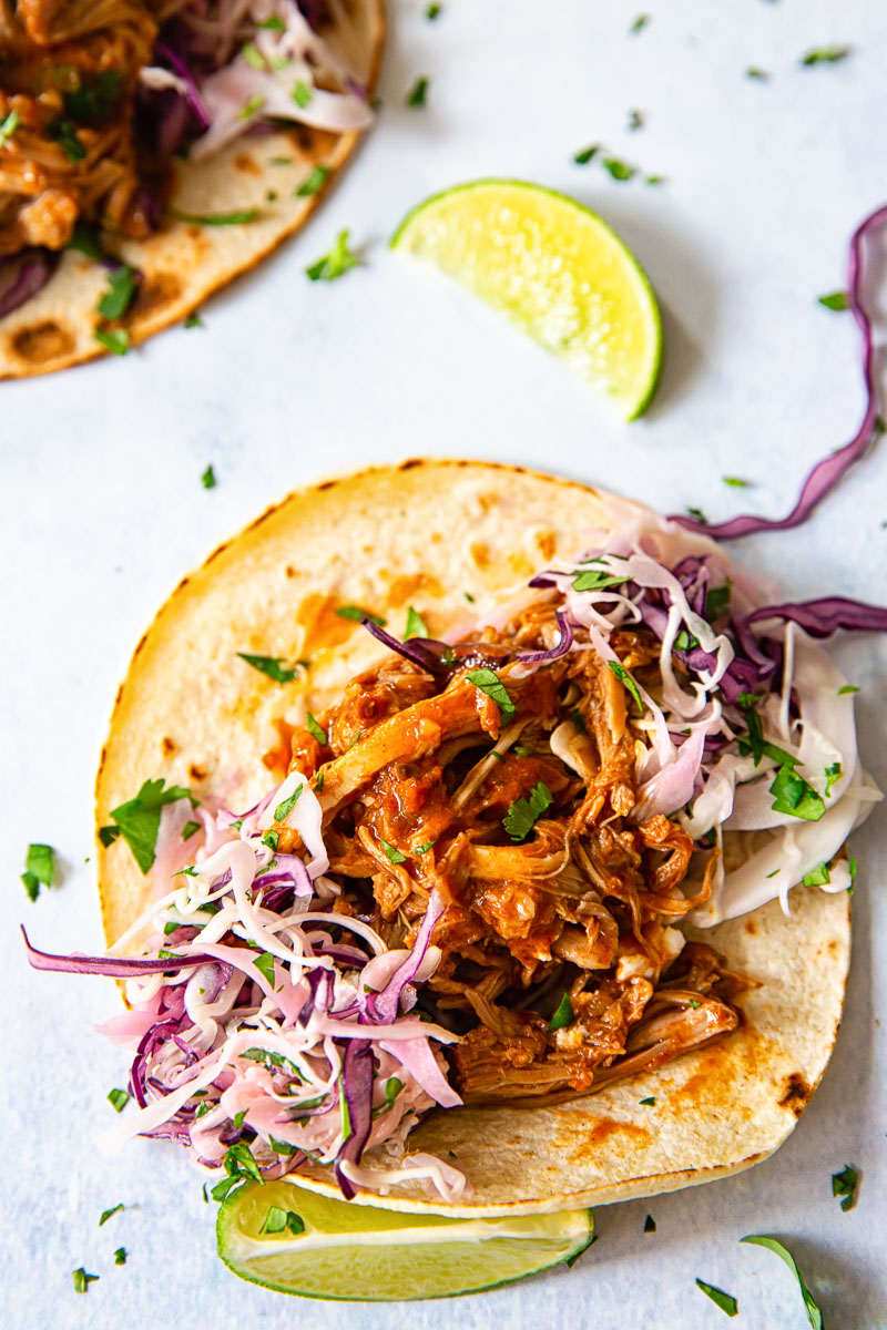 soft taco topped with pulled pork and slaw