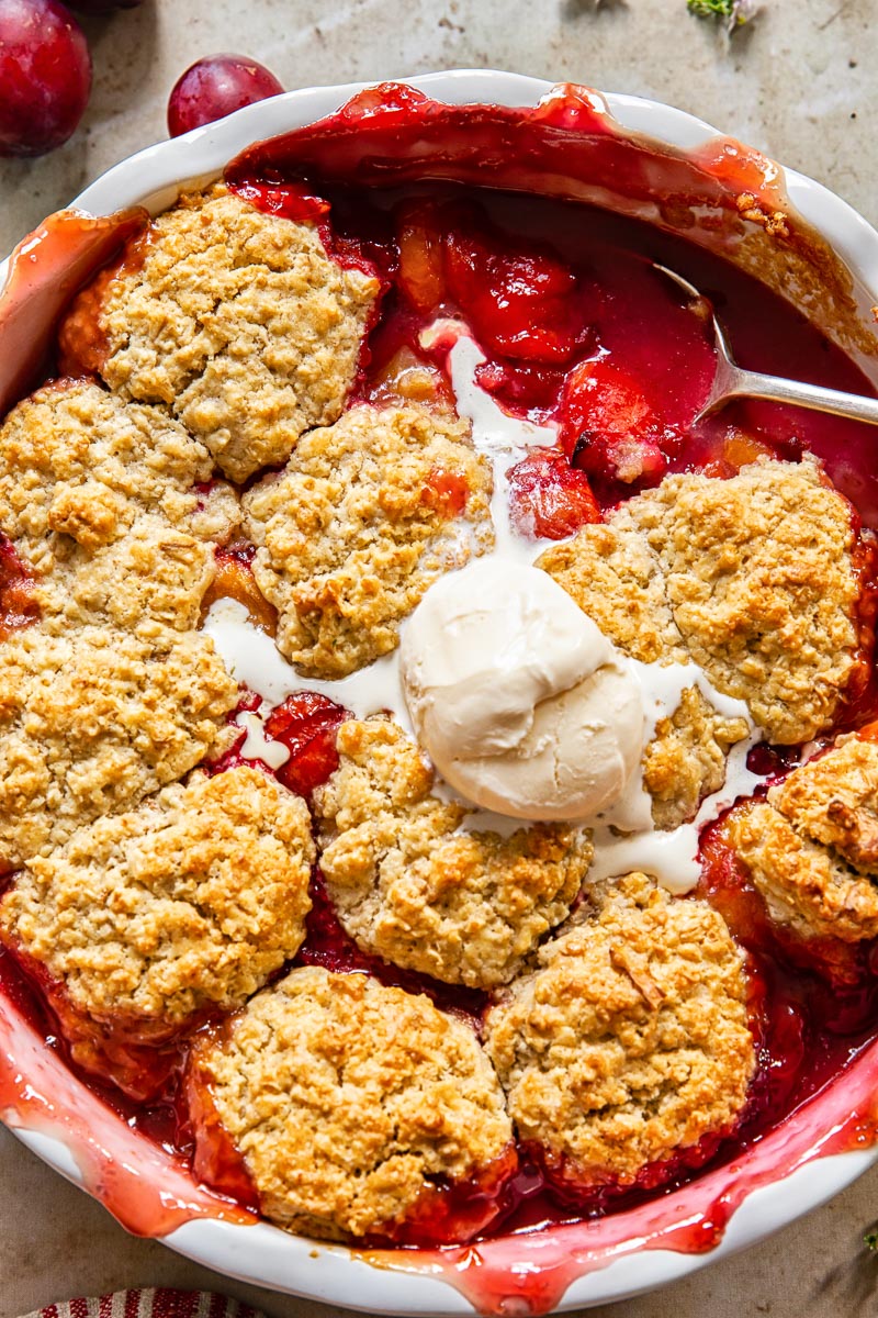 plum cobbler with a scoop of vanilla ice cream on top