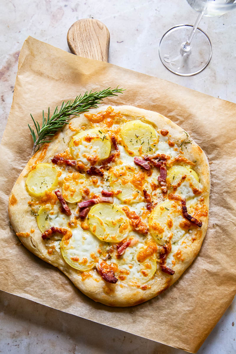 top down view of pizza bianca on brown parchment paper on top of wooden board