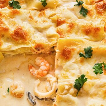 close up image of seafood lasagna with white sauce