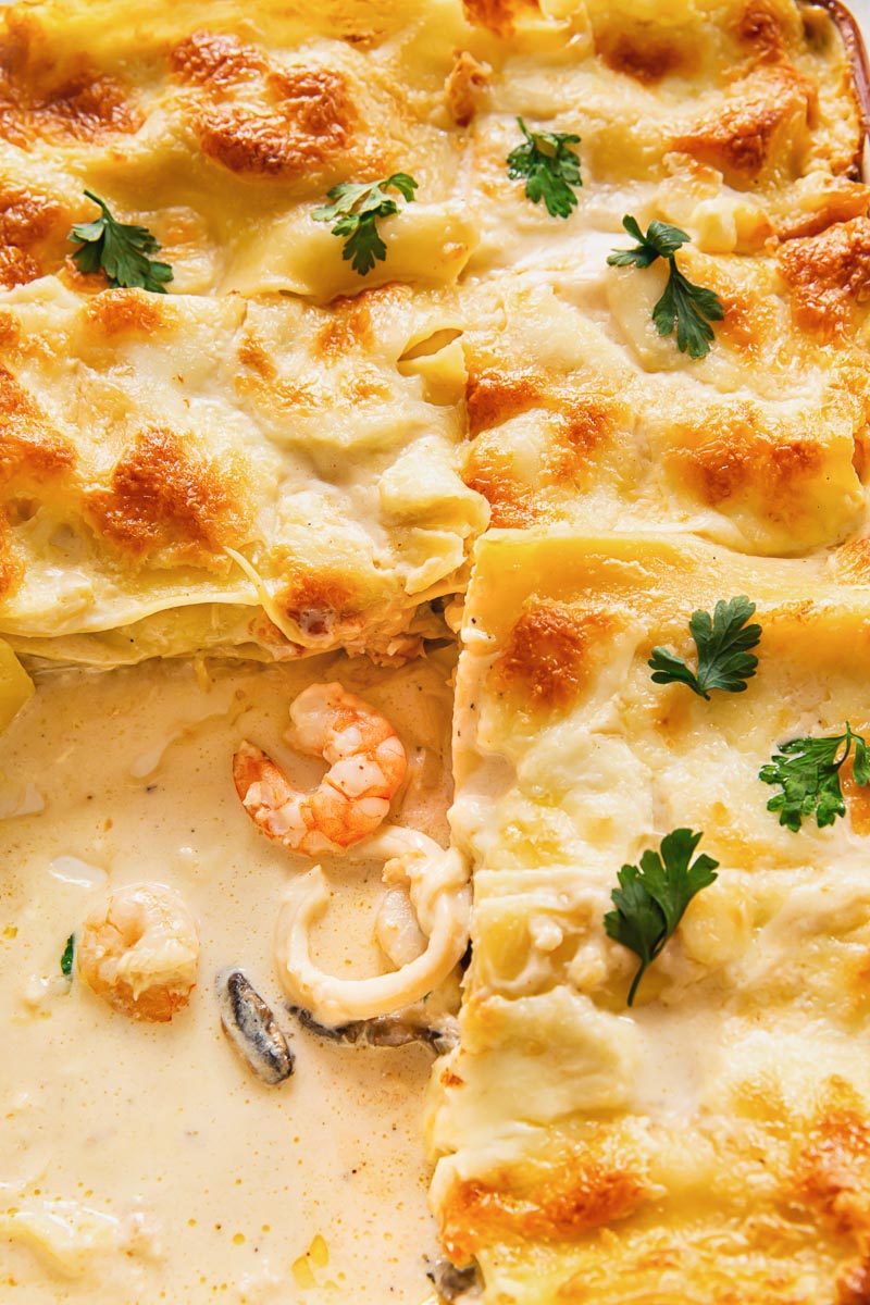 close up image of seafood lasagna with white sauce