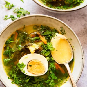 soup topped with greens and a hard boiled egg
