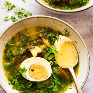 soup topped with greens and a hard boiled egg