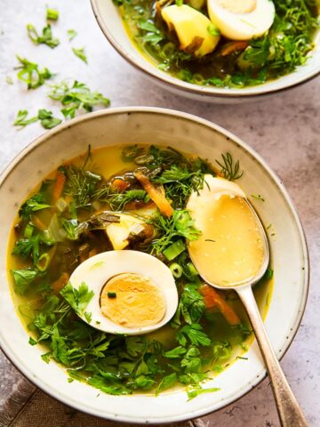 soup topped with greens and a hard boiled egg
