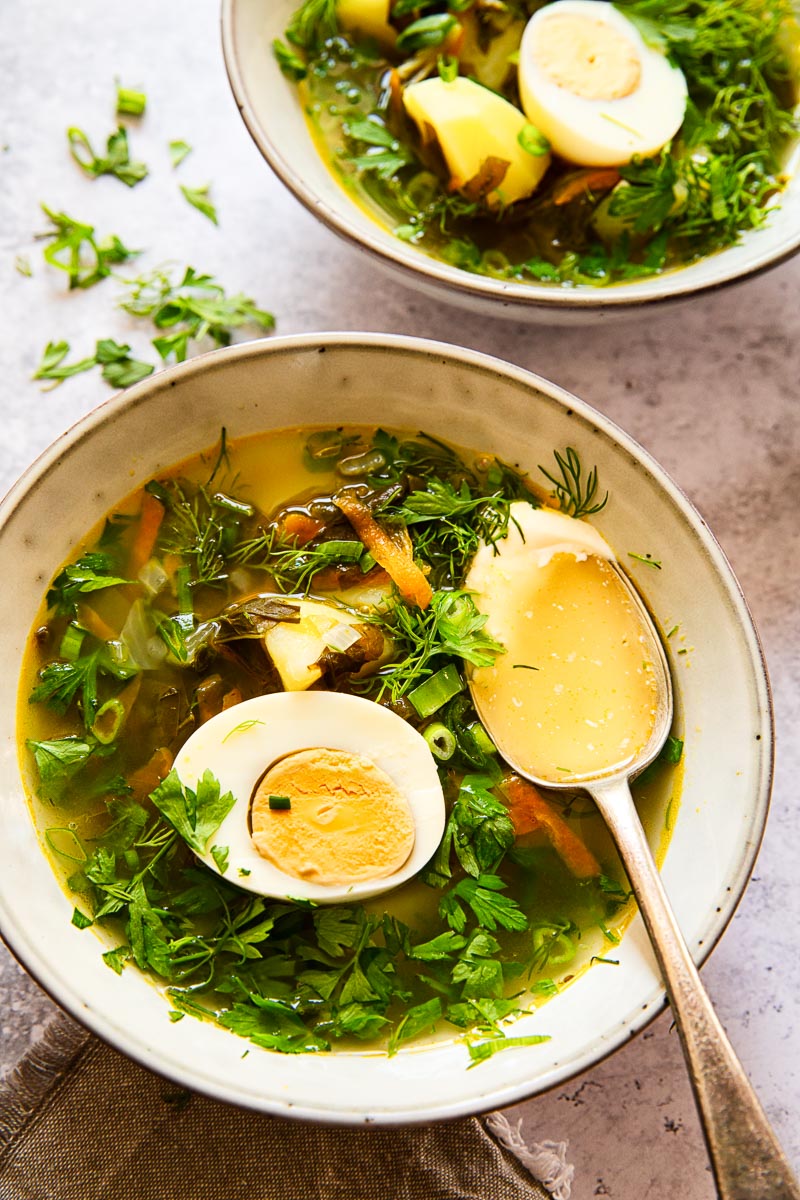 soup topped with greens and a hard boiled egg