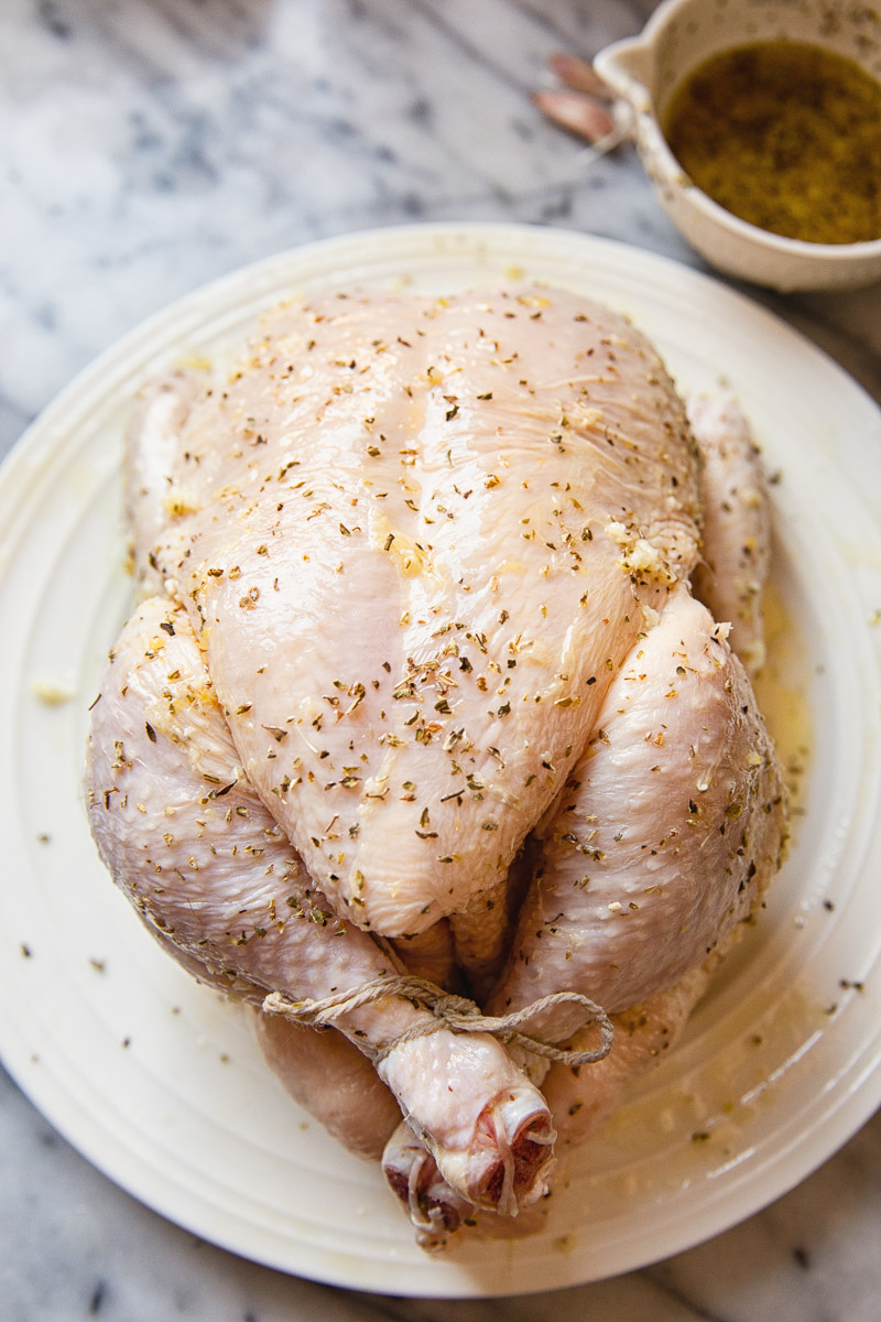 whole chicken raw, covered in marinade