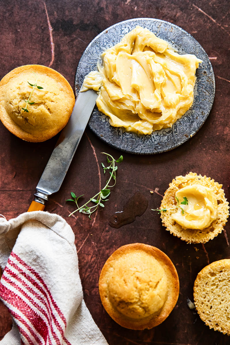 maple butter in a dish, butter knife, cornbread muffins, napkin