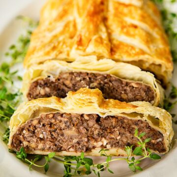 mushroom wellington on white platter with gold rim