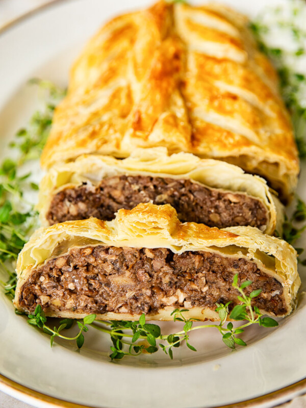 mushroom wellington on white platter with gold rim