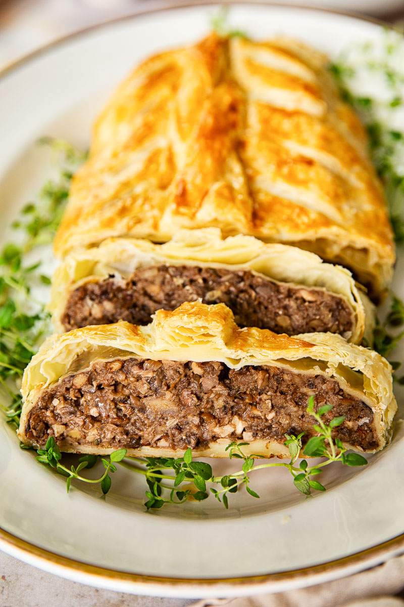 mushroom wellington on white platter with gold rim