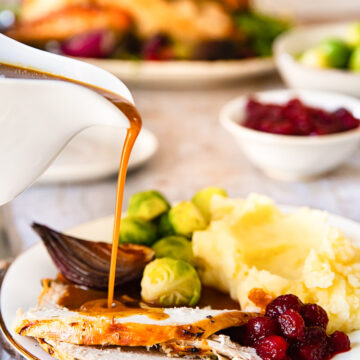 gravy being poured on sliced of turkey