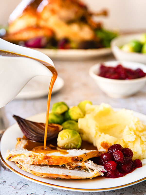 gravy being poured on sliced of turkey