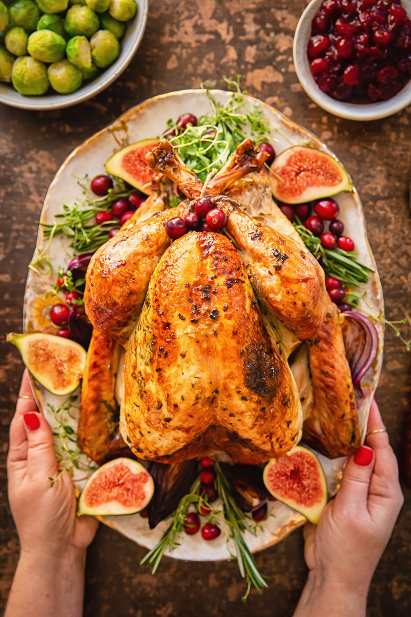 roast turkey garnishes with figs, herbs and cranberries