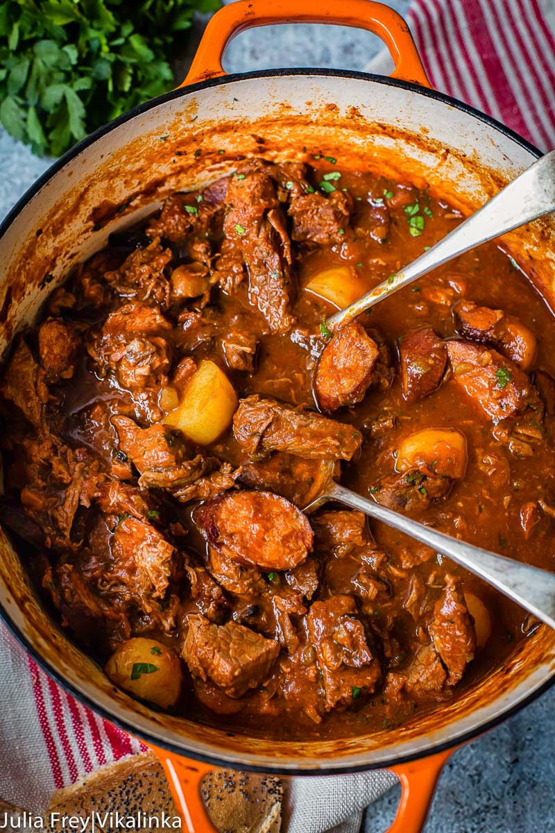 top down view of beef and sausage stew in orange pot