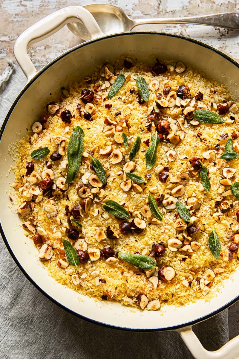 sweet potato casserole with breadcrumb and nut topping in cream pan