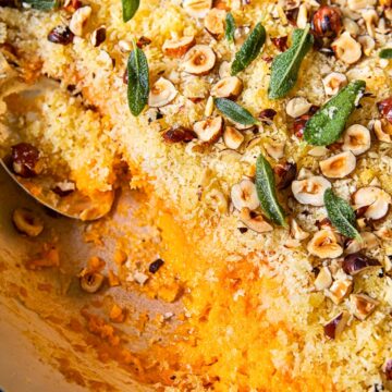 top down view of sweet potato casserole with breadcrumbs, hazelnuts and sage leaves