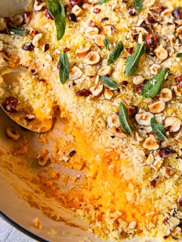top down view of sweet potato casserole with breadcrumbs, hazelnuts and sage leaves