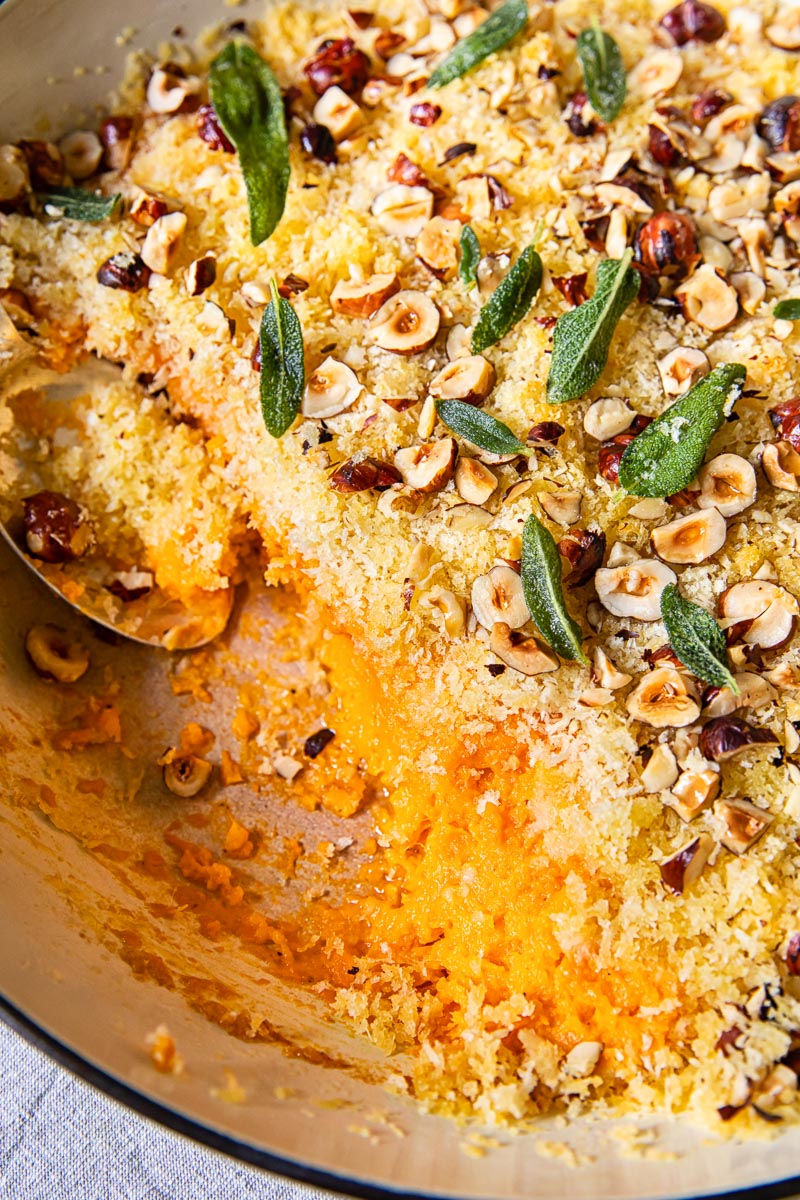 top down view of sweet potato casserole with breadcrumbs, hazelnuts and sage leaves
