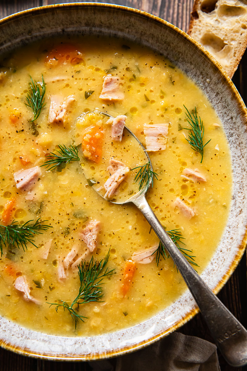 top down view split pea and ham soup in a bowl with a spoon in it