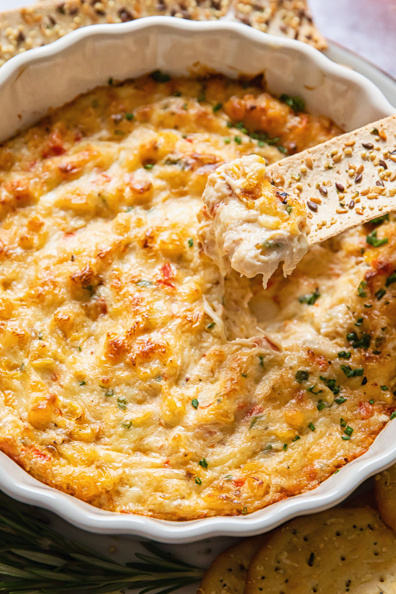 cheesy crab dip and a cracker dipped into it