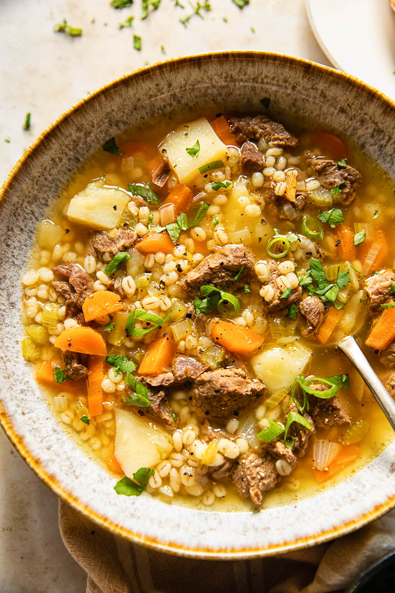 Beef Barley Soup sprinkled with herbs and green onions