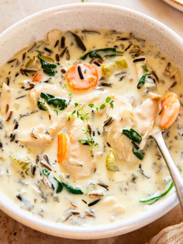 chicken wild rice soup in a creamy bowl with a spoon inside the bowl