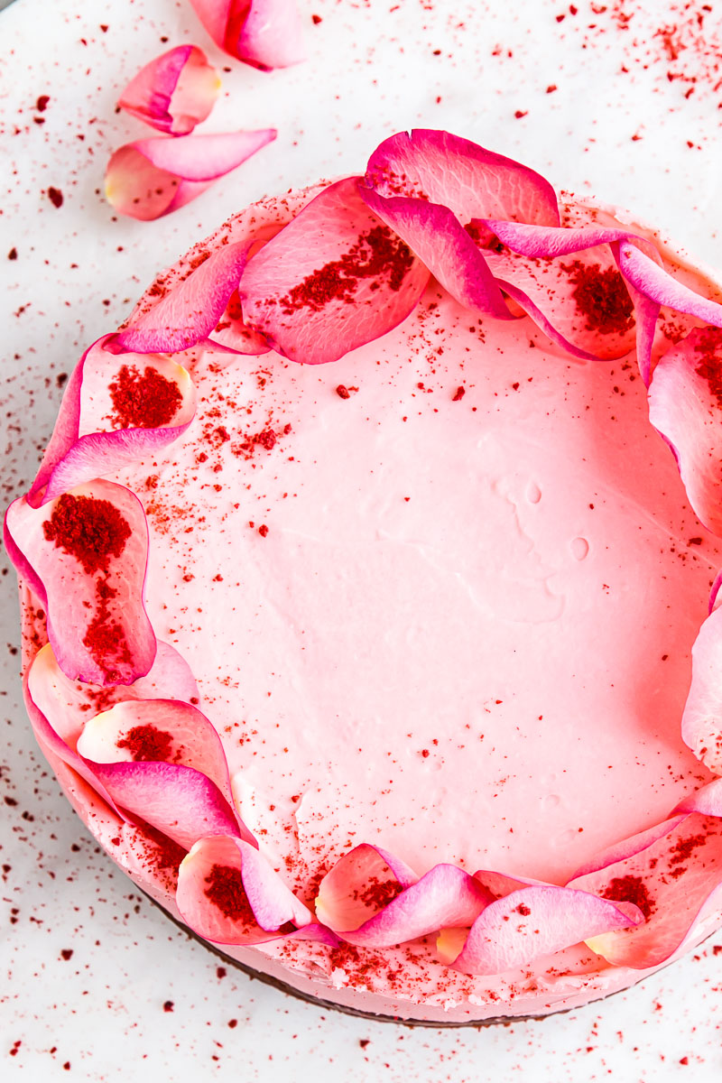 top down view of pink cake decorated with rose petals