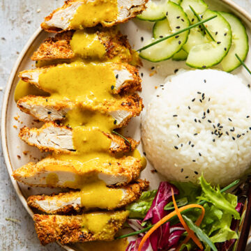 chicken katsu with curry poured over, rice, sliced cucumber