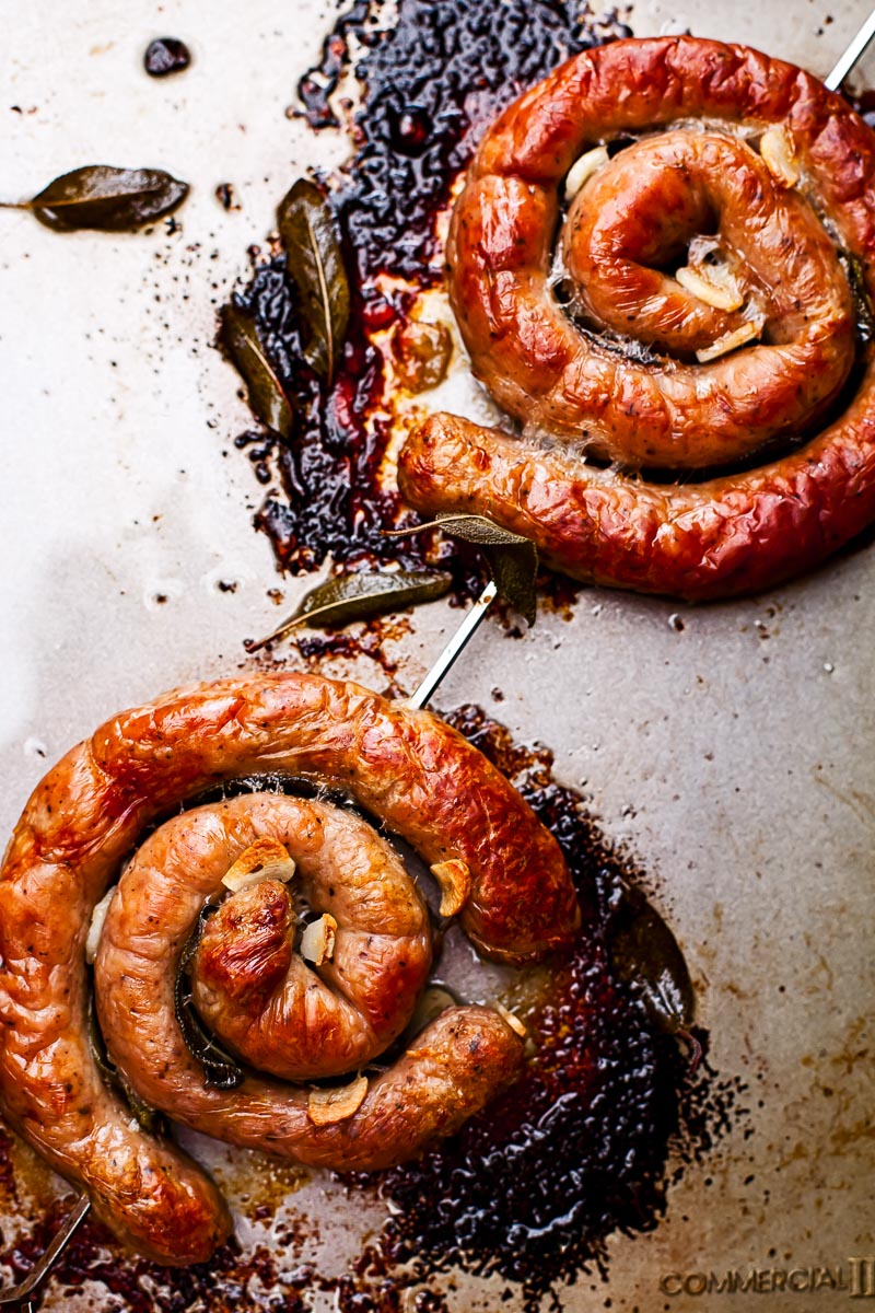 two sausage wheels on a skewer on a baking sheet