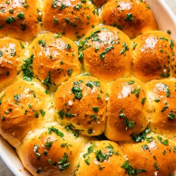 top down view of dinner rolls brushed with melted herb and garlic butter