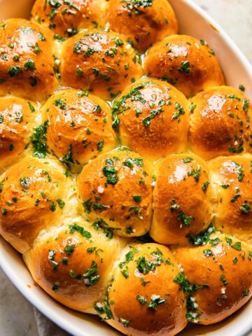 top down view of dinner rolls brushed with melted herb and garlic butter