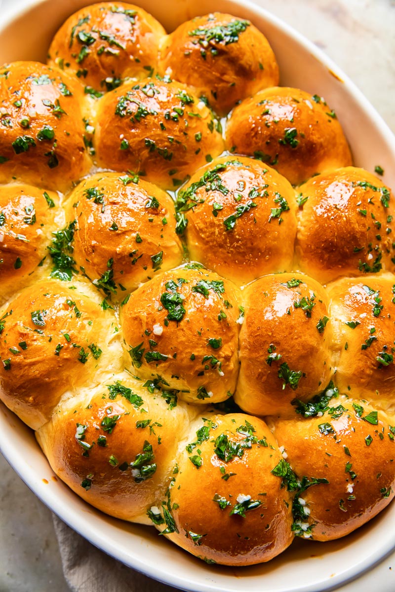 top down view of dinner rolls brushed with melted herb and garlic butter