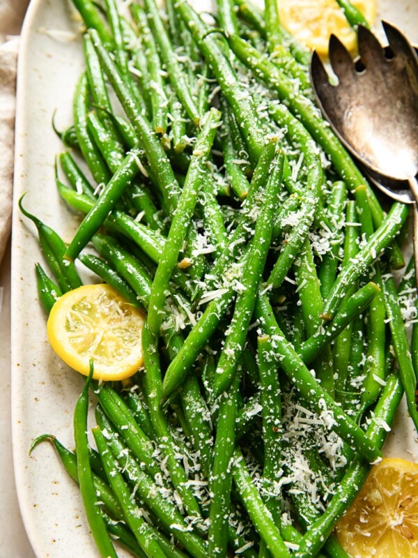 green beans topped with Parmesan and slices of lemon on a platter