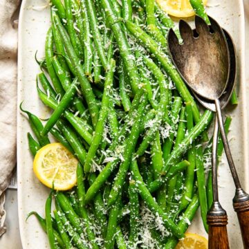 top down view of green beans with lemon slices and Parmesan