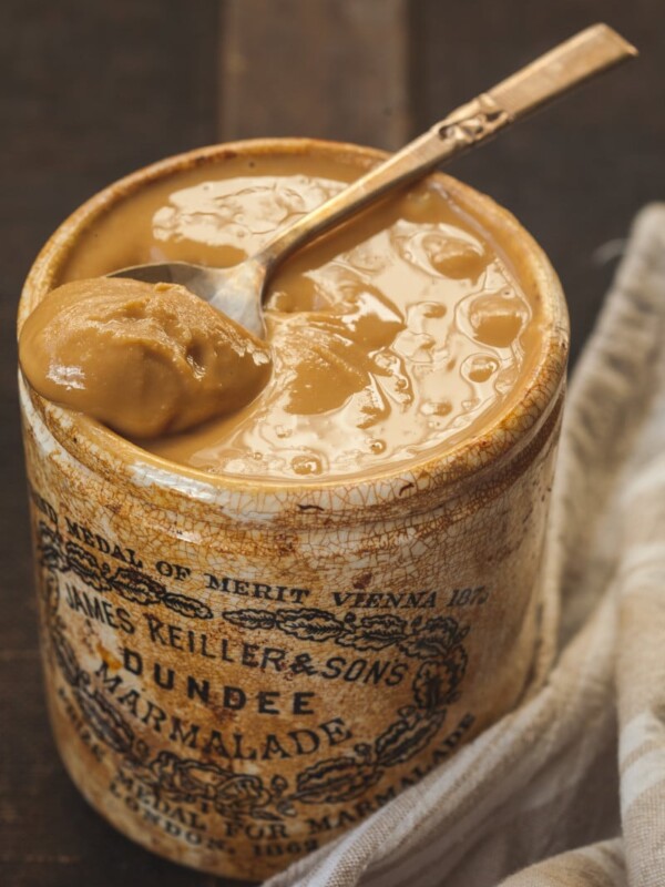 peanut butter in a brown jar with a spoon in it