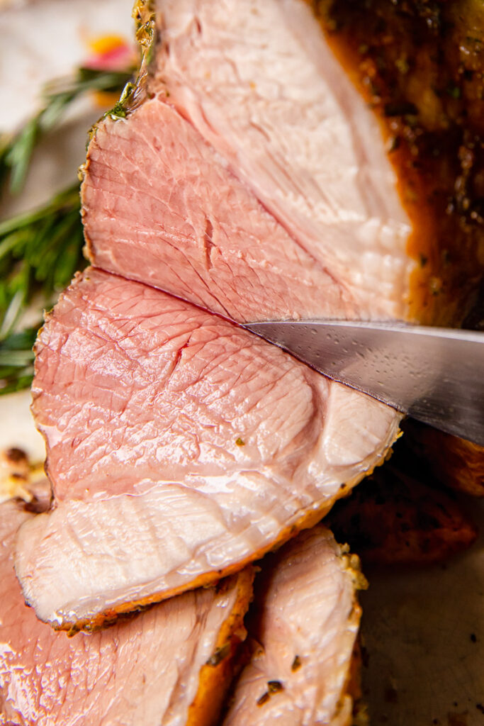 side view of roast lamb being sliced