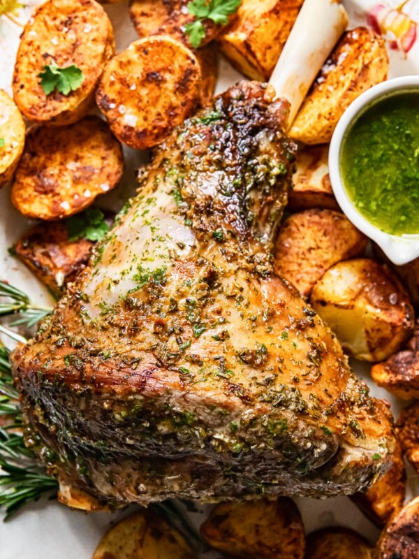 top down view of roast leg of lamb, mint sauce and roast potatoes