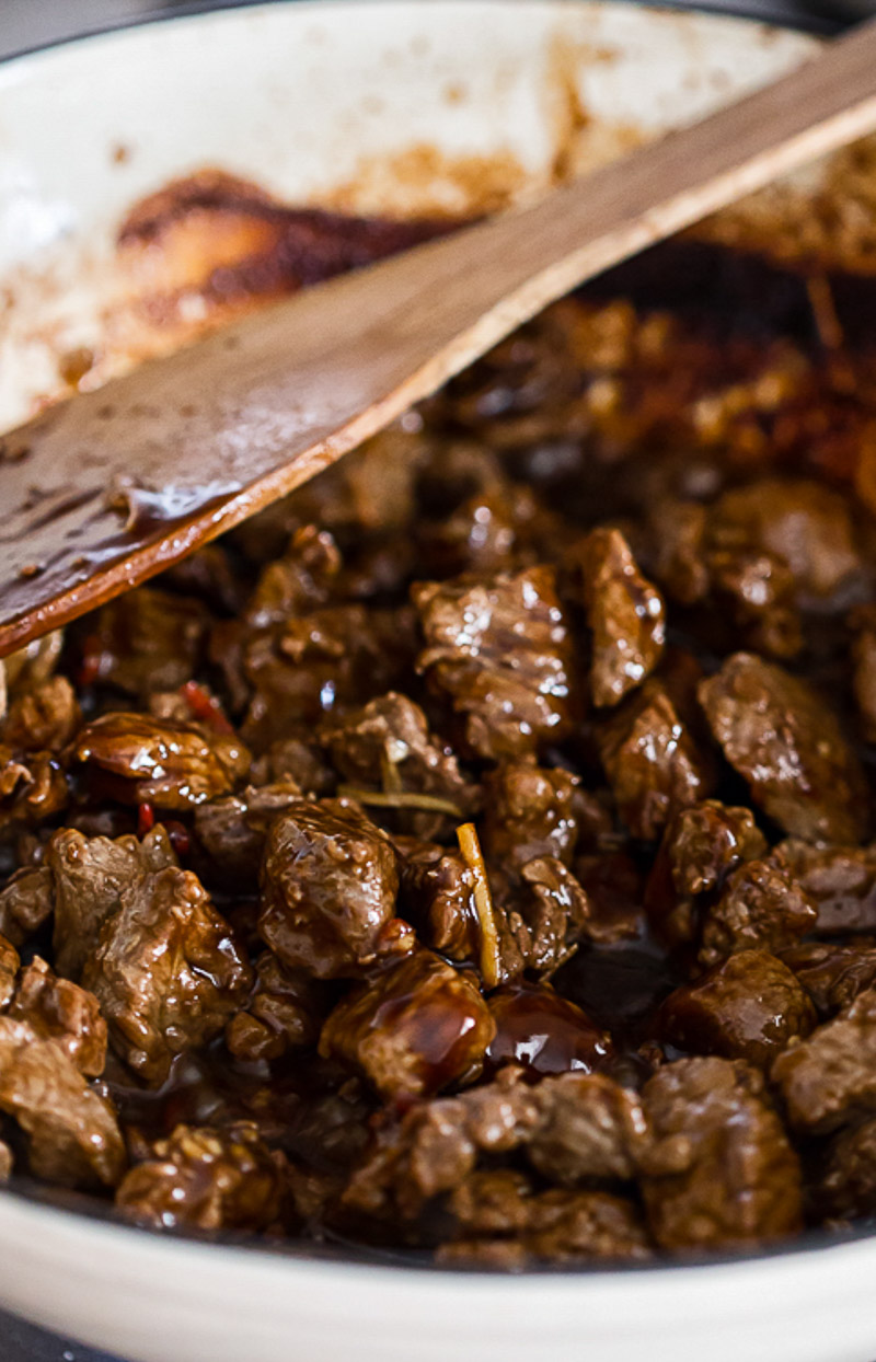 beef stir fry in a white frying pan