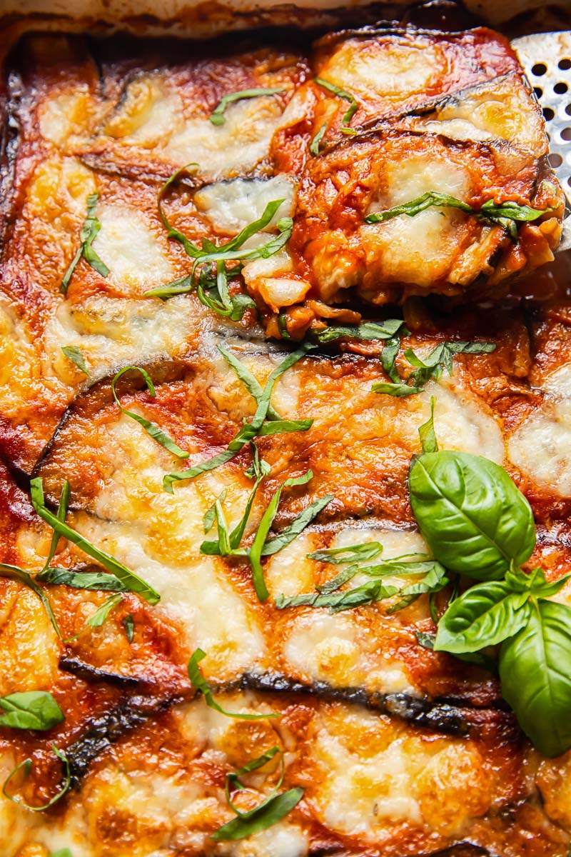 close up of eggplant parmigiana with a slice being lifted out of the pan