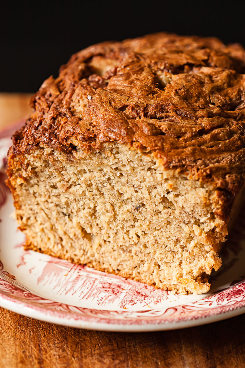 banana bread on a plate with the first slice cut off