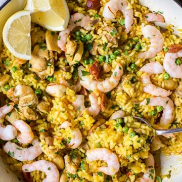 top down view of yellow Spanish rice with chicken, shrimp and lemon slices